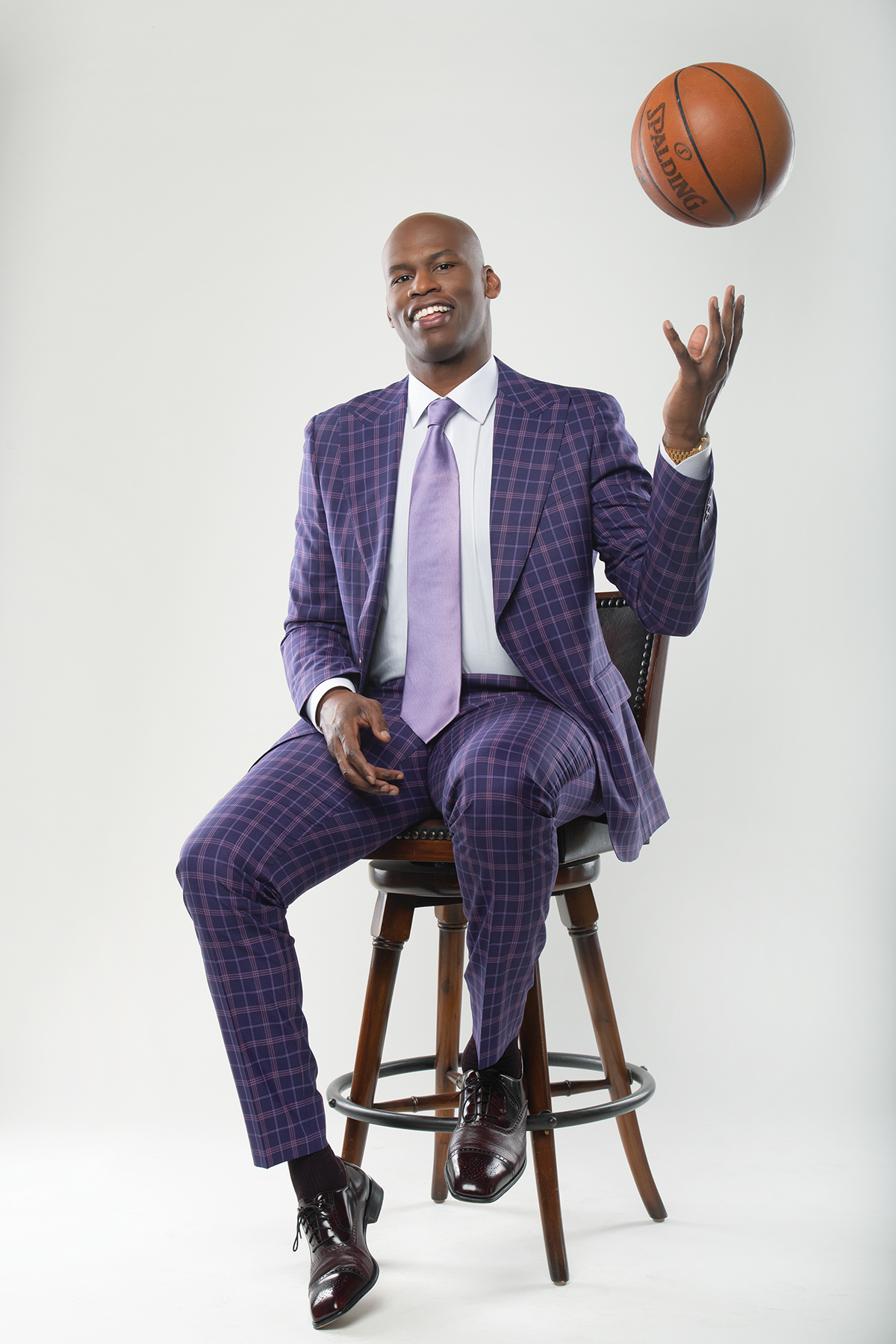 Al Harrington with a basketball in a purple suit and tie for Viola Brands