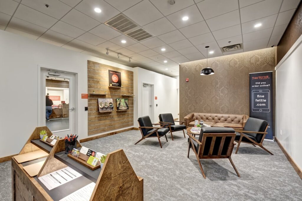 dispensary lobby with gray floor, light wood mid century furniture and a paneled ceiling