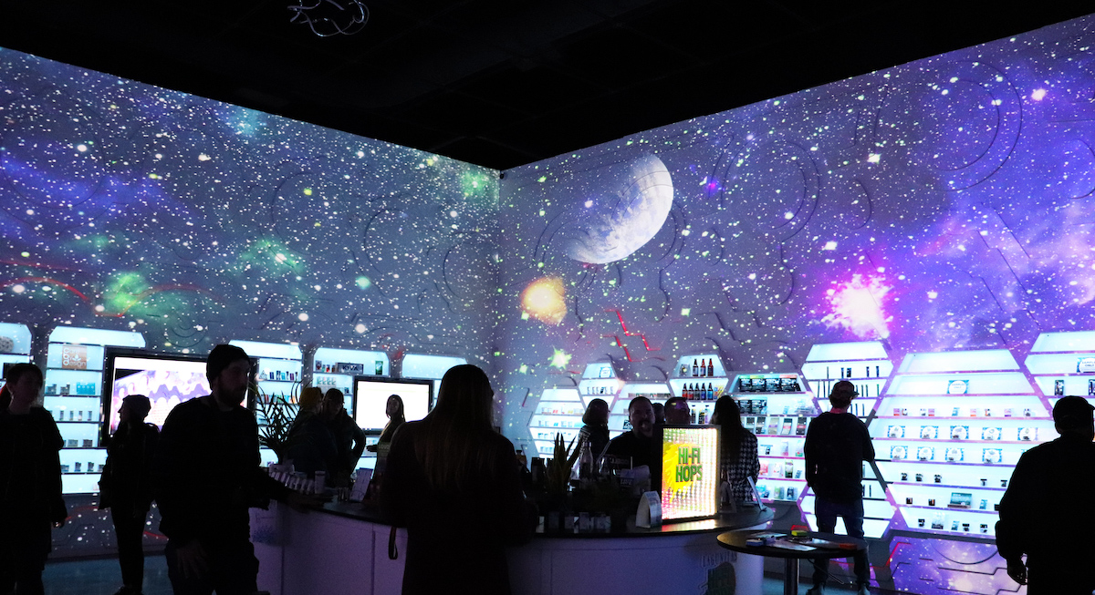 galaxy walls in low lit dispensary with people milling about 