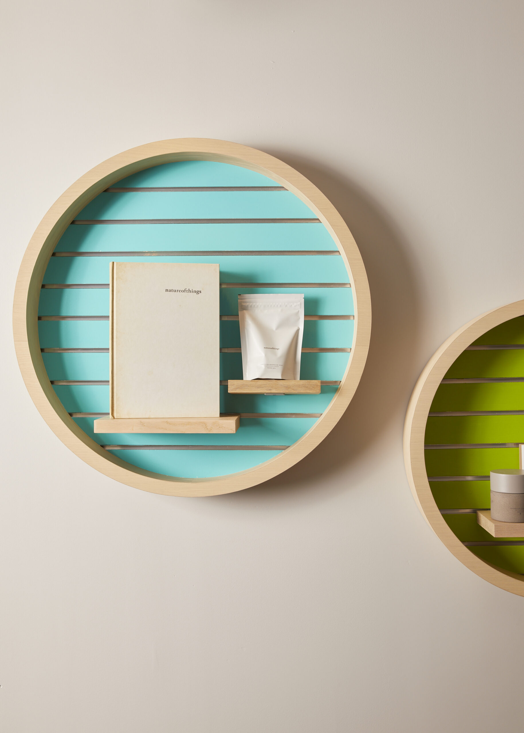 teal circular floating shelf with beige products displayed in the center