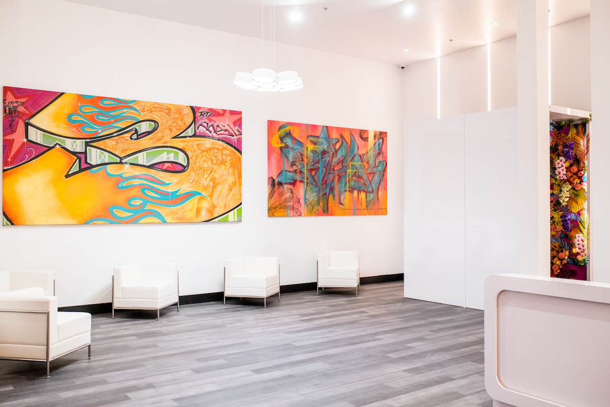 white room with white chairs and large colorful paneled graffiti art on the walls