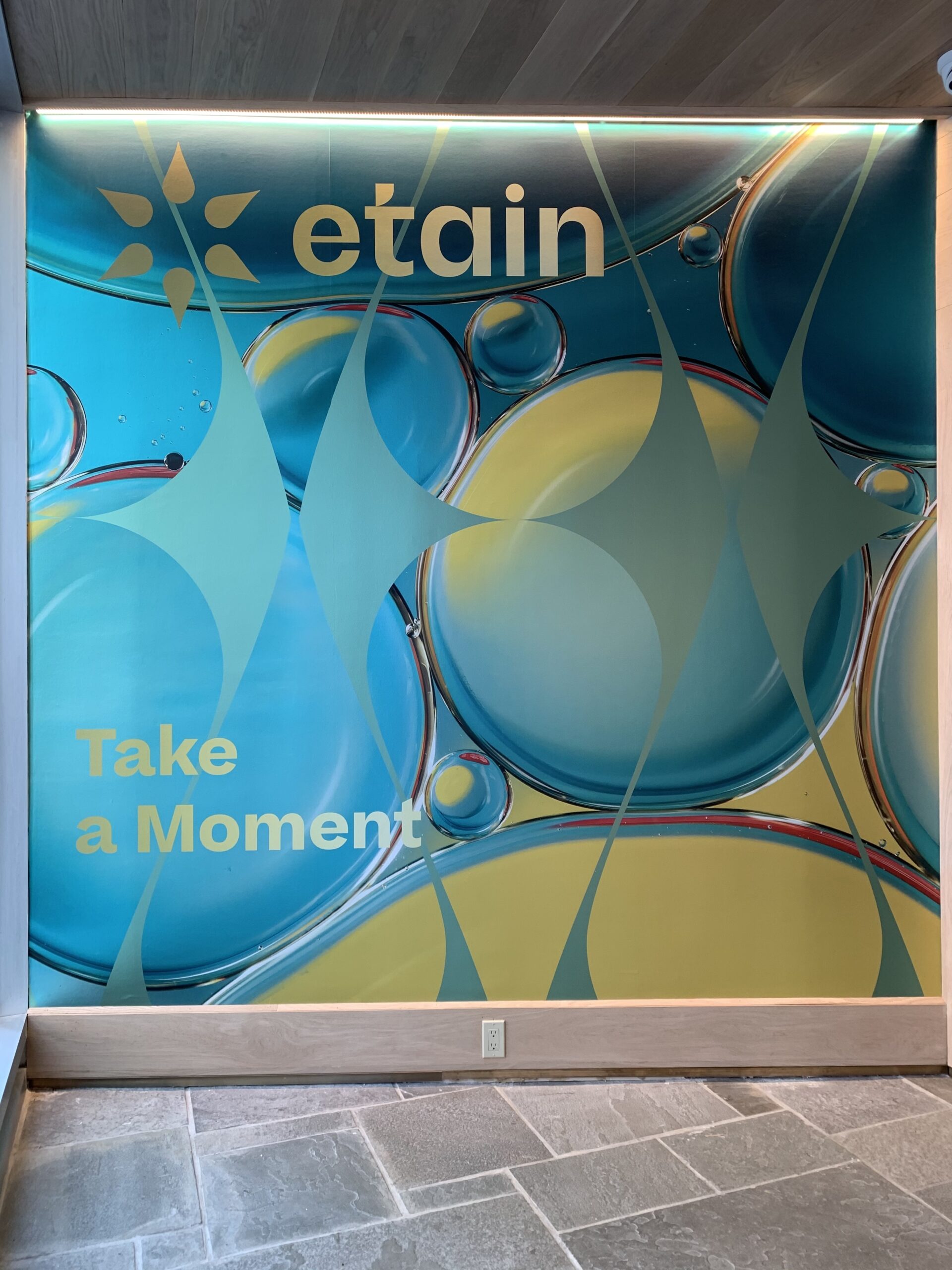entry wall to etain with blue and yellow abstracts designs and a sign that says take a moment 
