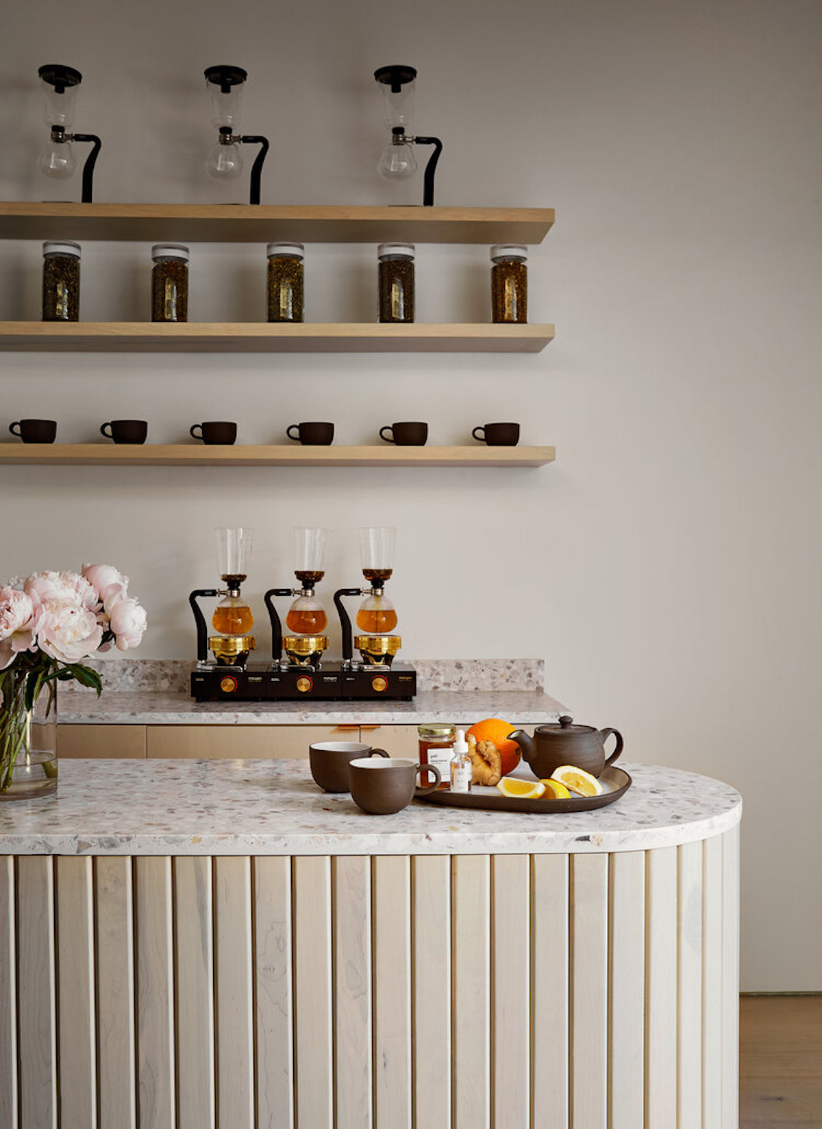 beige room with beige counter and tea and fresh fruit arranged on the surfacee