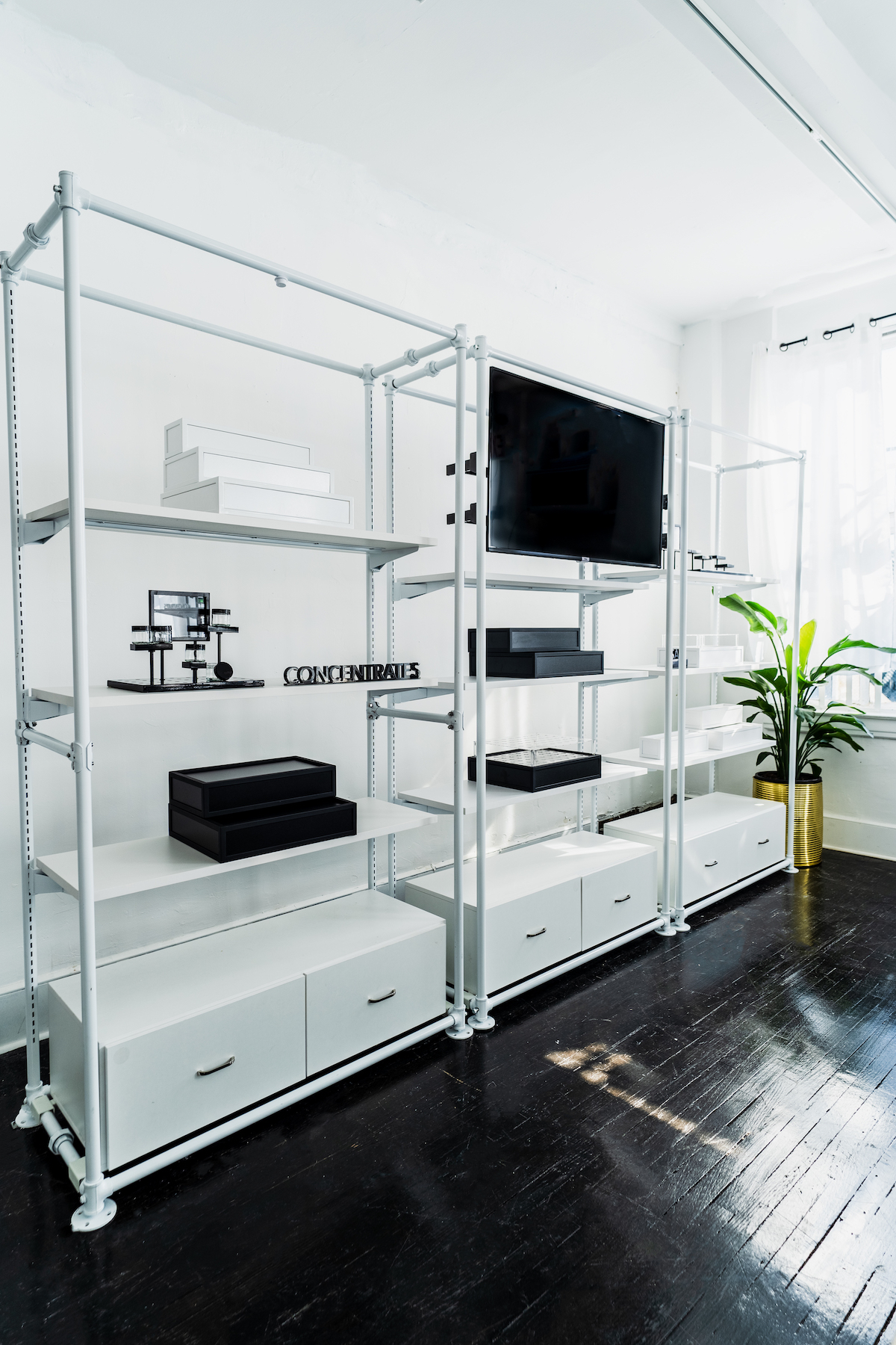 white wall with open display shelves and a black tv screen 