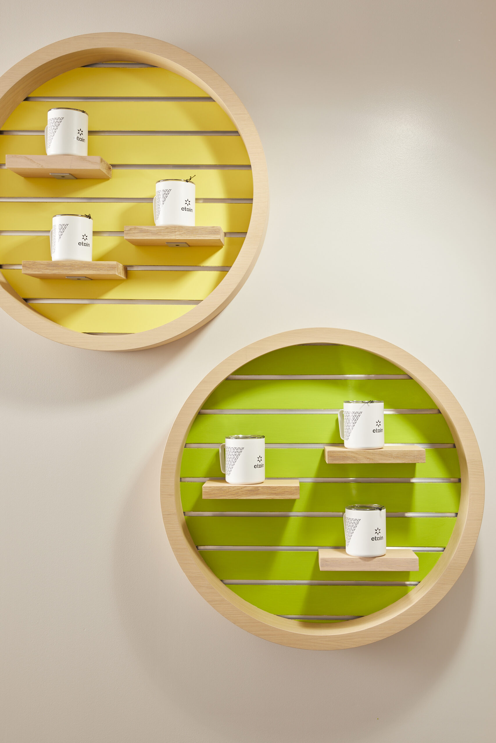 floating shelves on a white wall the interior of one is yellow and the other is lime green with white boxed products displayed in the center