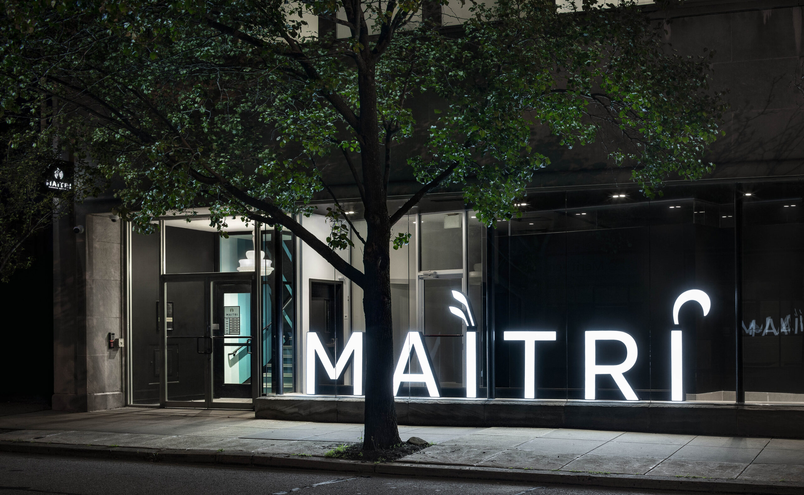 outside of dispensary with MAITRI logo in white florescent lighting 