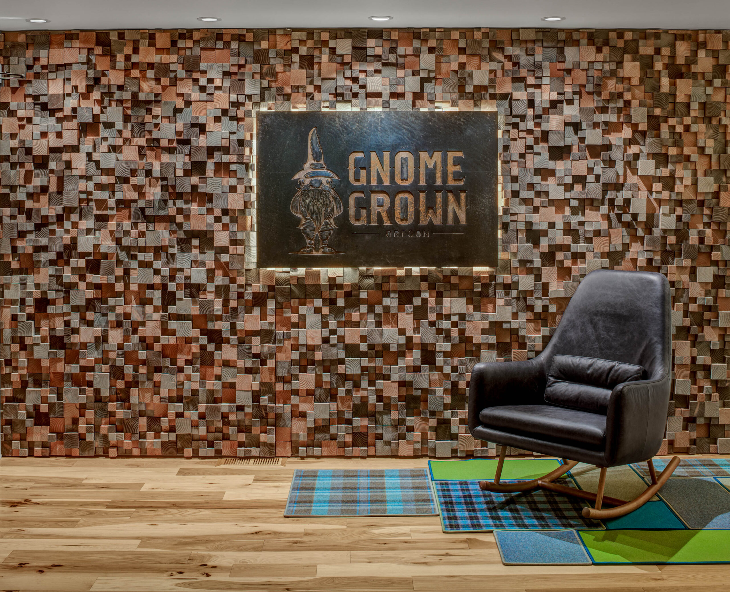 wall with Gnome Grown logo and a black chair 